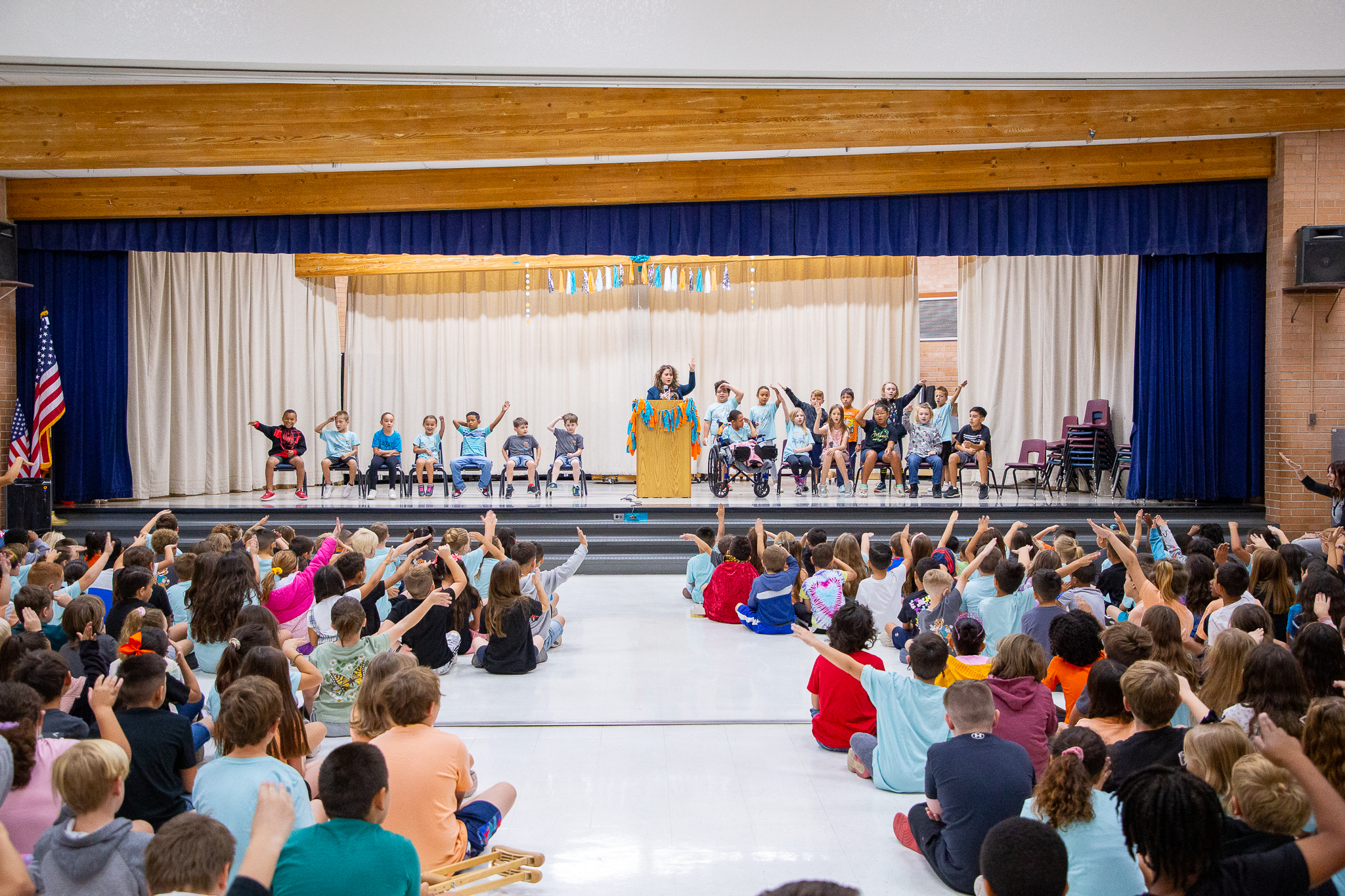 Students wave their arms during a school assembly